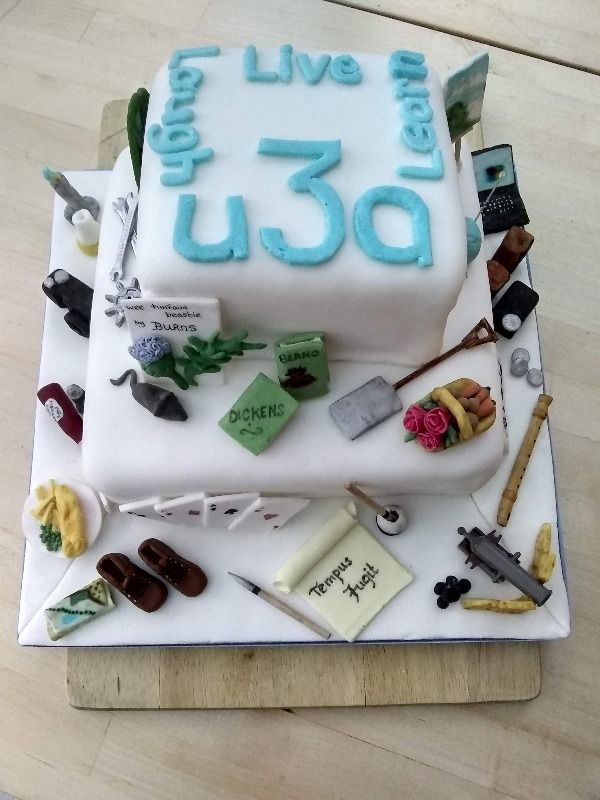 u3a decorated two tier cake with colourful decorations of different u3a activities