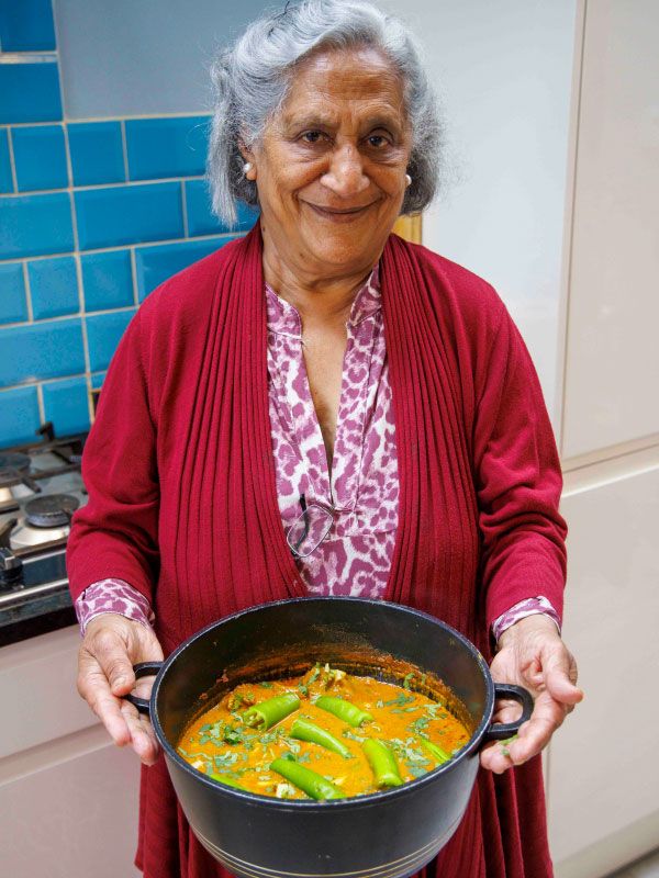 Photo of a competition winner holding a pot with curry