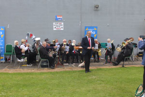 A band playing music with a man in a suit in the foreground