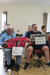 Two people in a musical choir playing along to song books