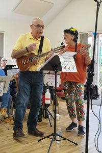 A man and woman standing playing musical instruments