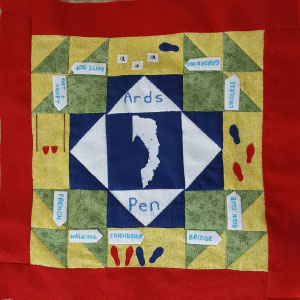 A quilted square made up of several coloured blocks and triangles of fabric with the words Ards Pen in the middle of the square