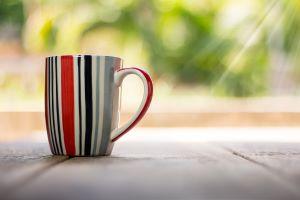 stripy cup of tea/ coffee outside with sun rays shining on it