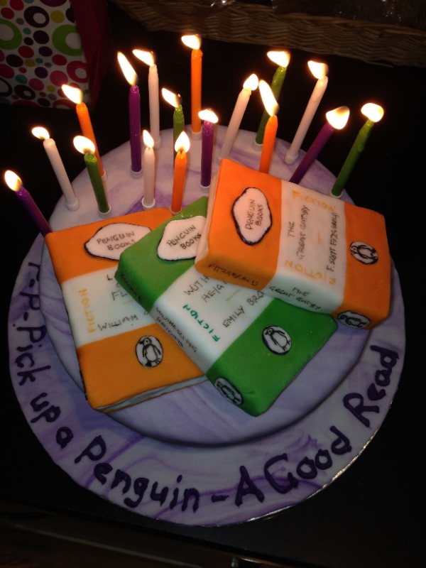 cake decorated with 3 penguin paperbacks made of icing and 17 colourful candles