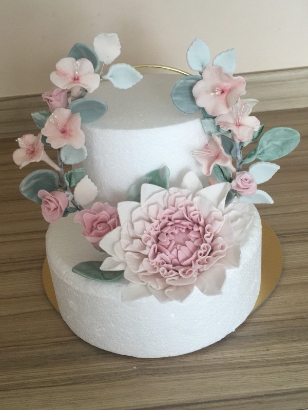 white cake with pastel pink sugarwork flowers