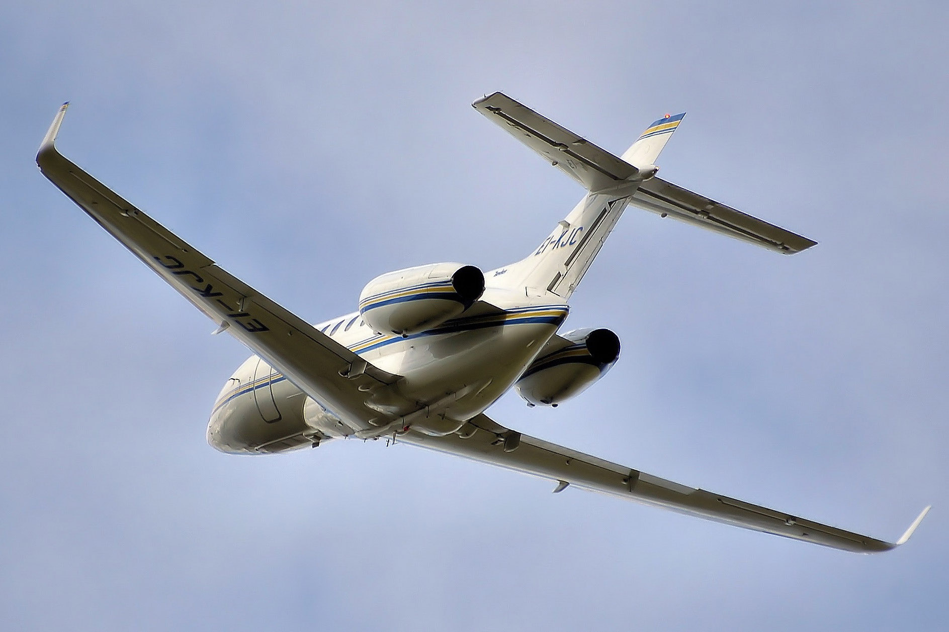 small white plane flying in blue sky