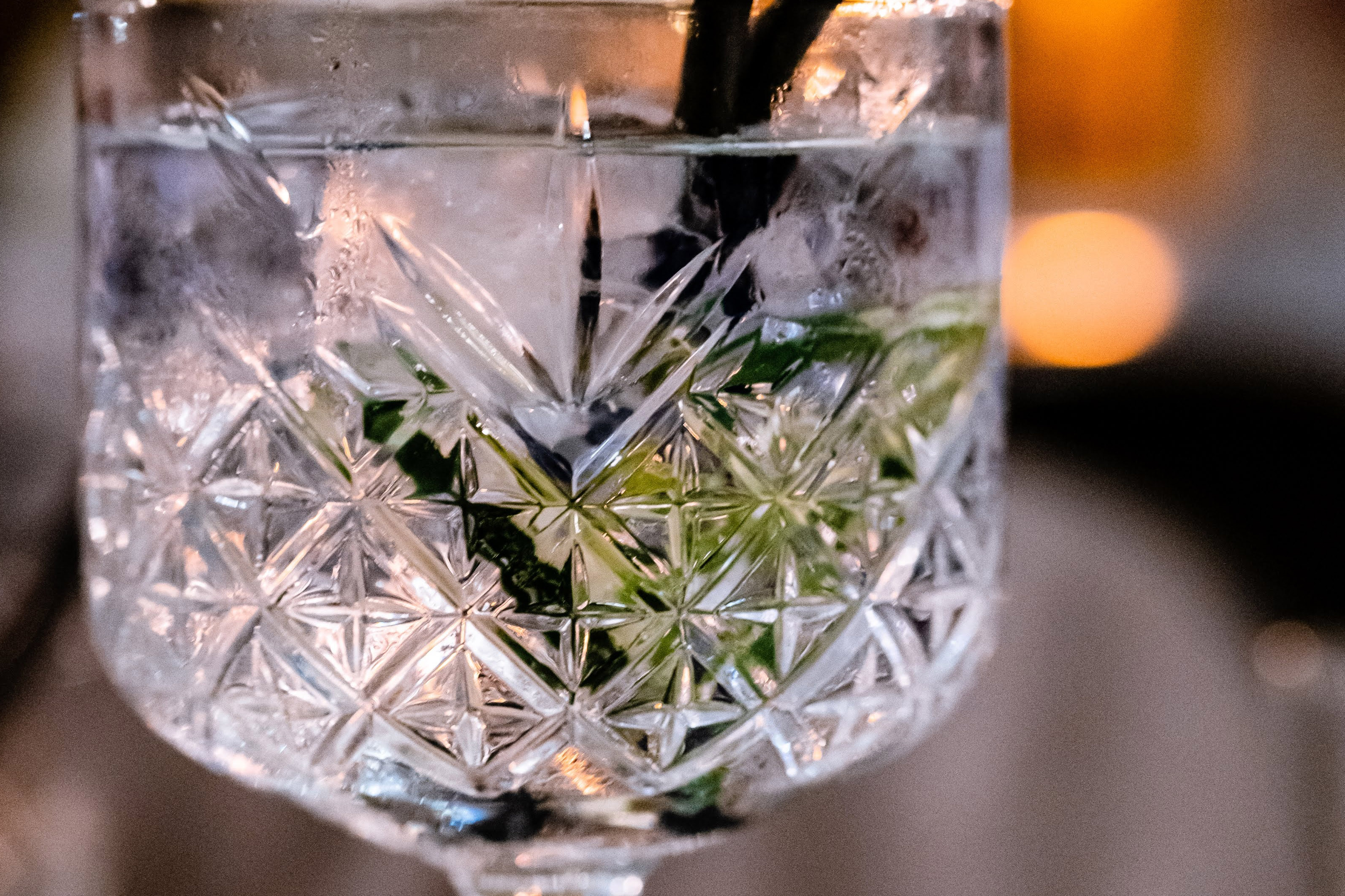 a crystal goblet with a clear drink in