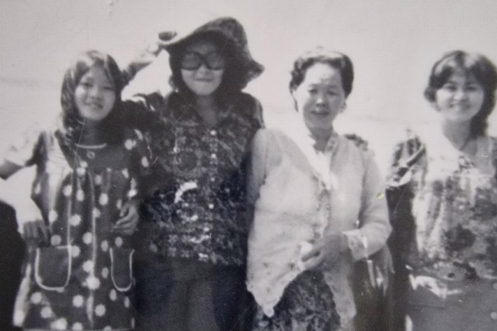 a black and white photo of 4 women in a line