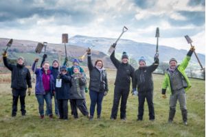 a group of people holding spades up