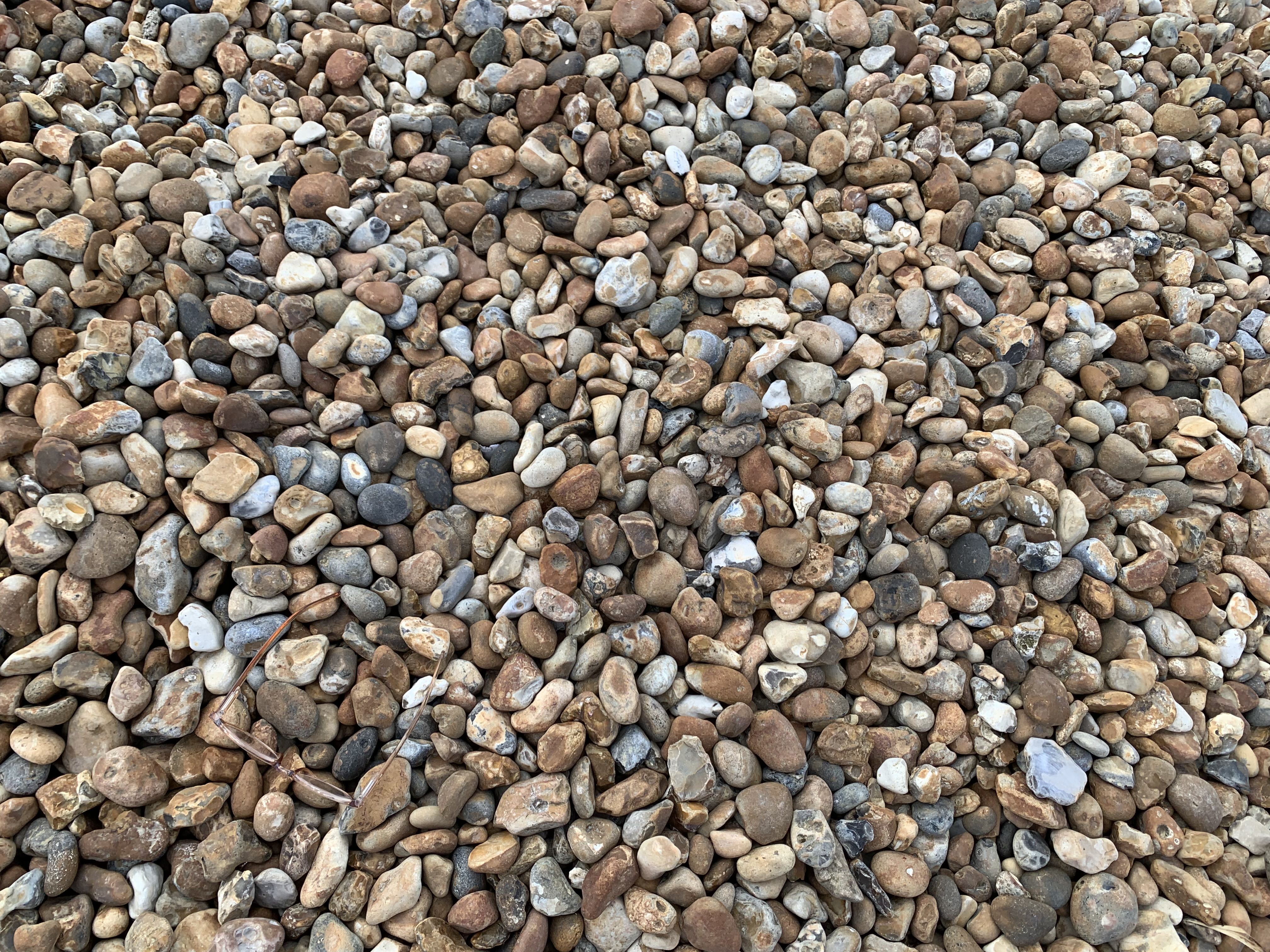 an aerial view of orange and brown and grey pebbles on a beach