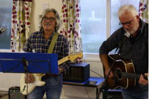 Two men playing guitar