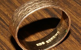 a gold scratched wedding ring on wooden surface