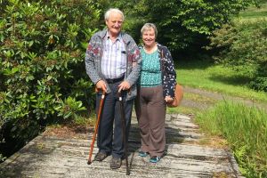 A man and woman standing outside in a garden
