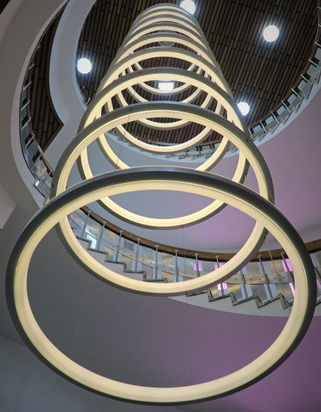 circular lights of diminishing size, photo taken from the ground looking up a spiral staircase