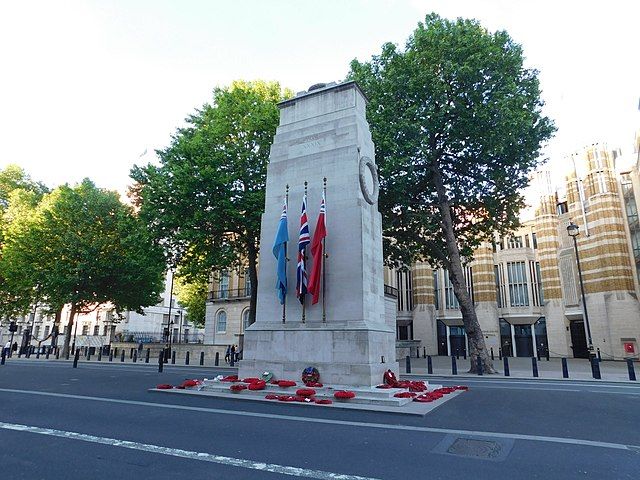 a war memorial with red poppy wreaths around it